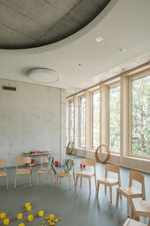 Interior view: facade in wood. Above lies the concrete ceiling